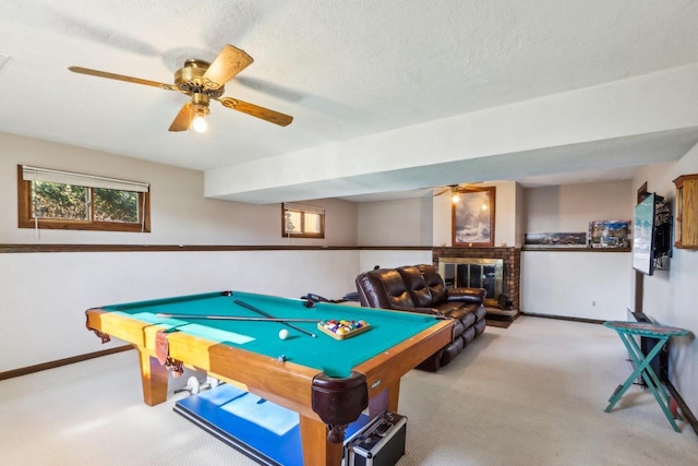 recreation room featuring a brick fireplace, pool table, a textured ceiling, and carpet flooring