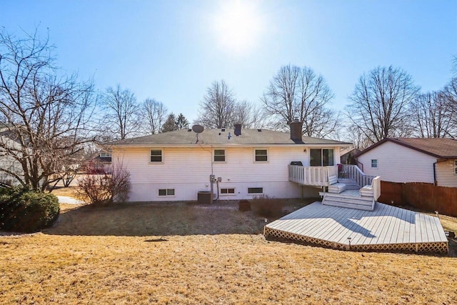 rear view of property with a lawn and a deck