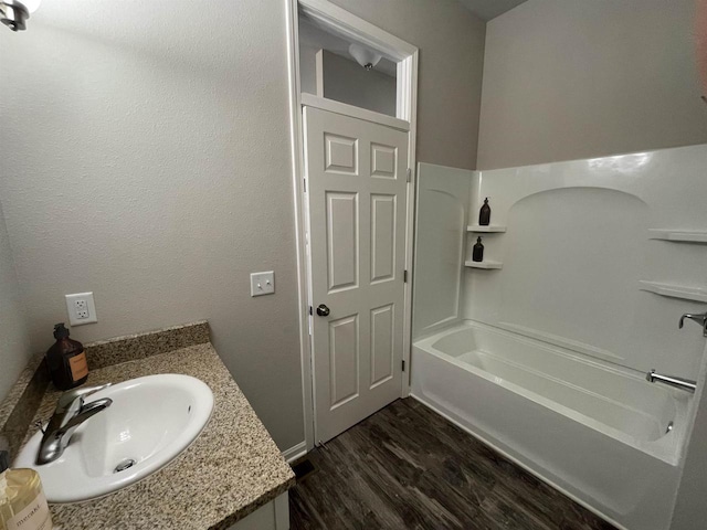 bathroom featuring vanity, hardwood / wood-style floors, and bathing tub / shower combination