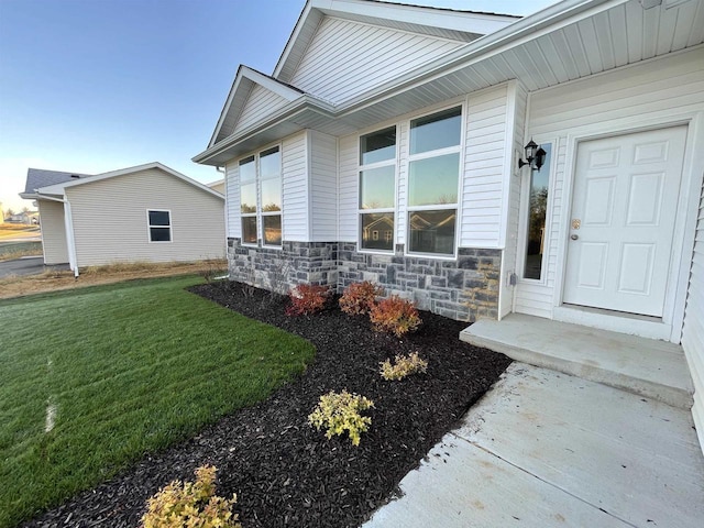 entrance to property with a lawn