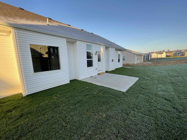 back of house featuring a patio area and a lawn