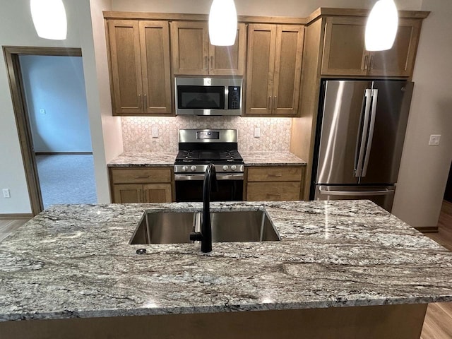 kitchen featuring sink, backsplash, stainless steel appliances, and stone counters