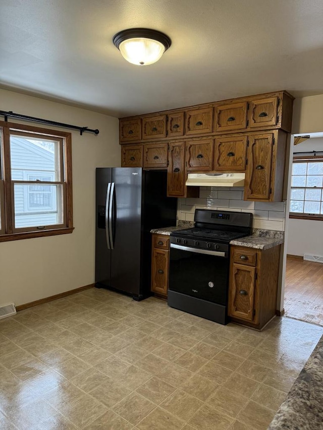 kitchen with backsplash and black appliances