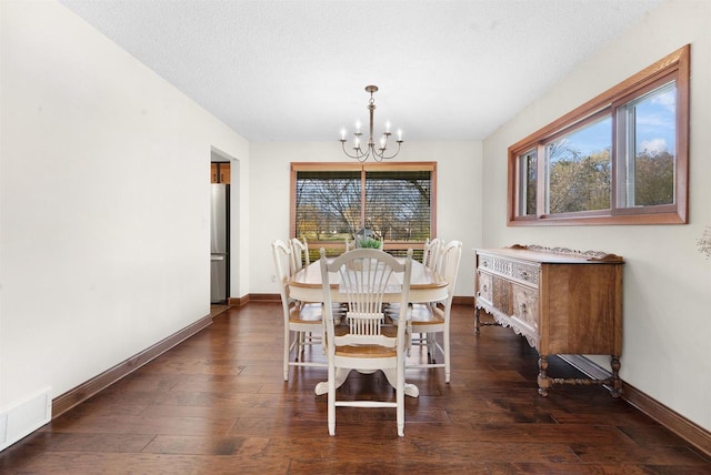 dining space with dark wood-type flooring, a chandelier, and a textured ceiling