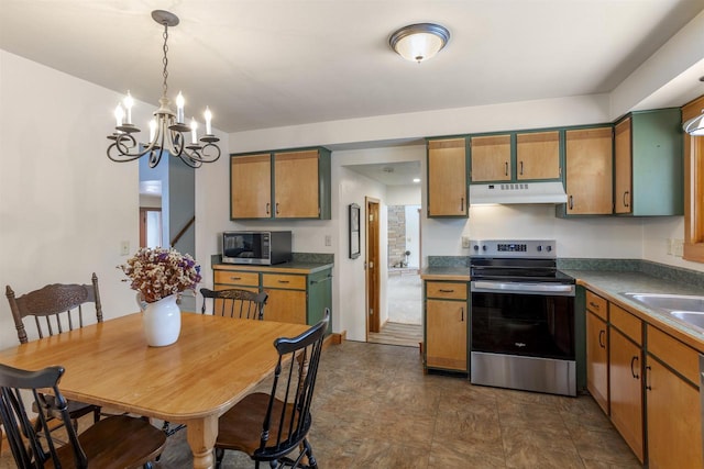 kitchen featuring appliances with stainless steel finishes, sink, pendant lighting, and an inviting chandelier