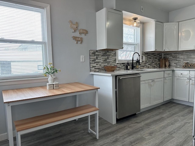 kitchen featuring stainless steel dishwasher, white cabinets, light wood-type flooring, and decorative backsplash