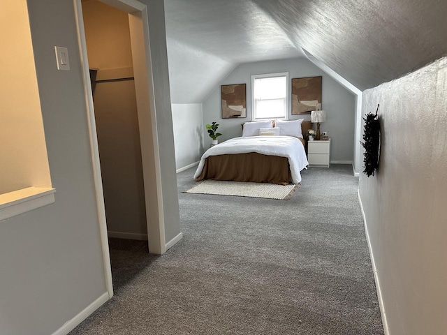 bedroom with vaulted ceiling, carpet, and a textured ceiling