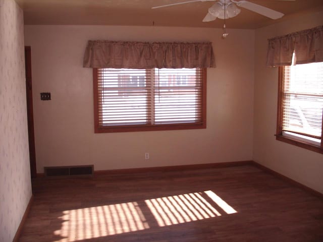 empty room with ceiling fan and dark hardwood / wood-style floors