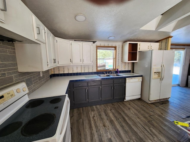 kitchen featuring dark hardwood / wood-style floors, white cabinetry, sink, and white appliances