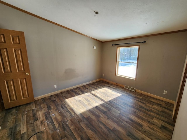 spare room featuring crown molding and dark hardwood / wood-style floors