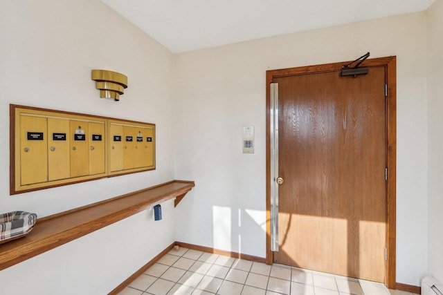 entrance foyer featuring a baseboard heating unit, light tile patterned floors, mail area, and baseboards