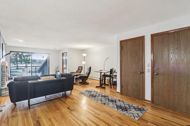 living area featuring light wood-style floors and a textured ceiling