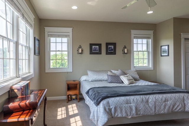 carpeted bedroom with multiple windows and radiator heating unit