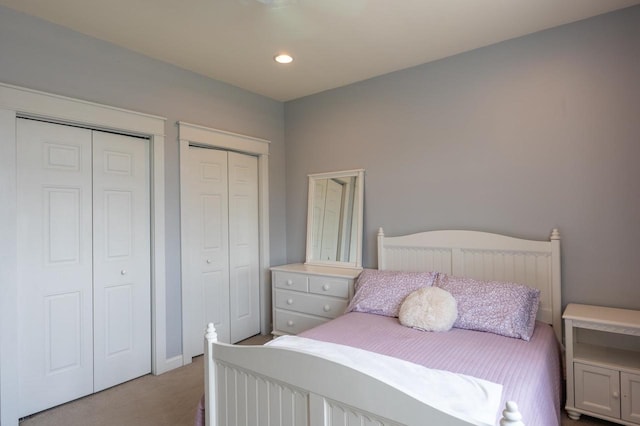 carpeted bedroom featuring two closets