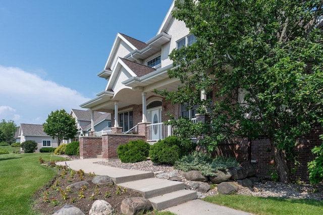 view of front of home with a porch and a front lawn