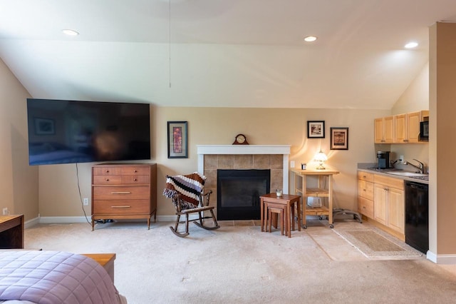 carpeted living room with a fireplace, sink, and vaulted ceiling