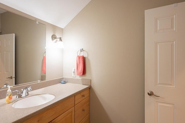 bathroom with vanity and lofted ceiling