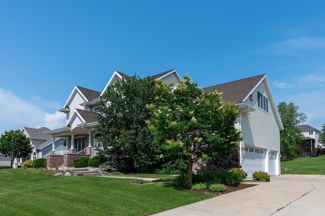 view of front of house featuring a garage, covered porch, and a front lawn