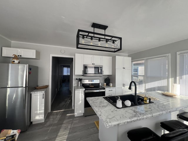 kitchen with white cabinetry, sink, pendant lighting, and stainless steel appliances