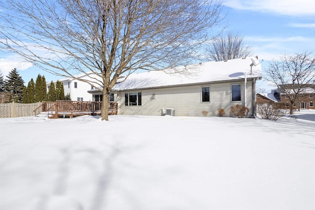 snow covered rear of property featuring a wooden deck and central air condition unit