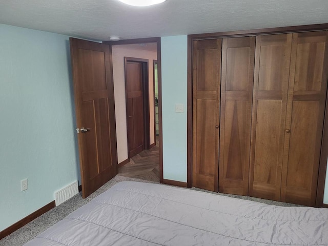 unfurnished bedroom with light parquet flooring, a textured ceiling, and a closet