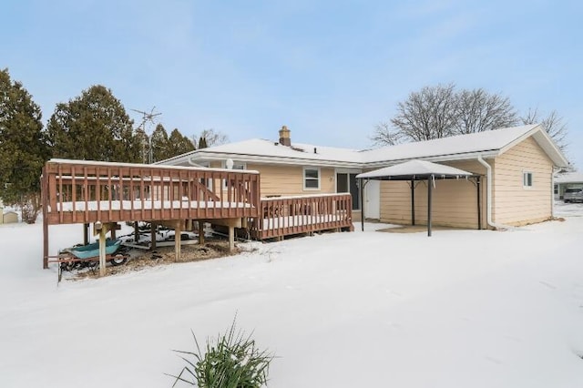 snow covered back of property featuring a deck