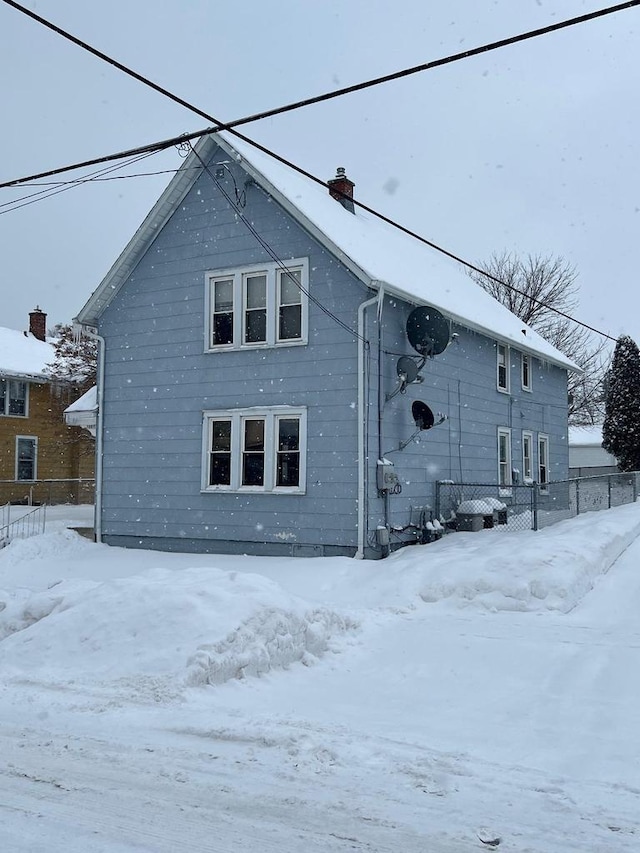 view of snow covered rear of property