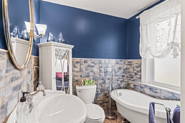 bathroom featuring sink, a tub, tile walls, and toilet