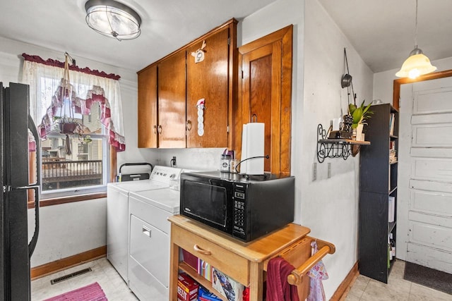 laundry area with washing machine and dryer and cabinets