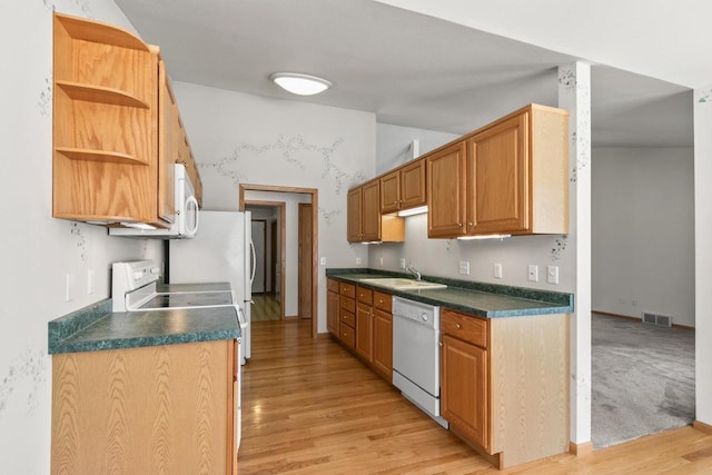 kitchen with sink, white appliances, and light hardwood / wood-style floors