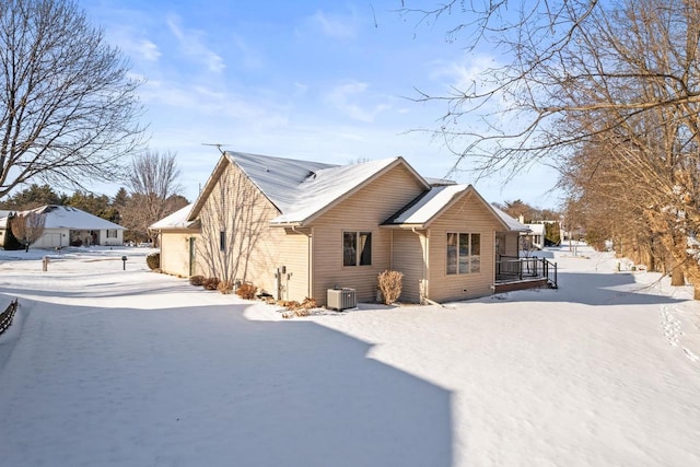 snow covered property with central AC unit