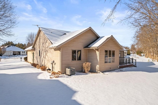 snow covered back of property with central AC unit