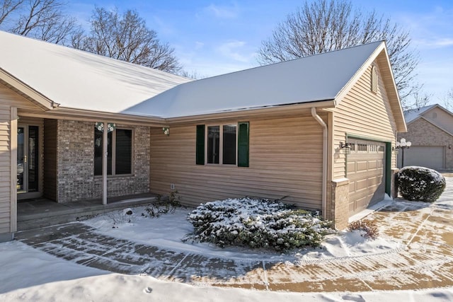 view of snow covered exterior featuring a garage