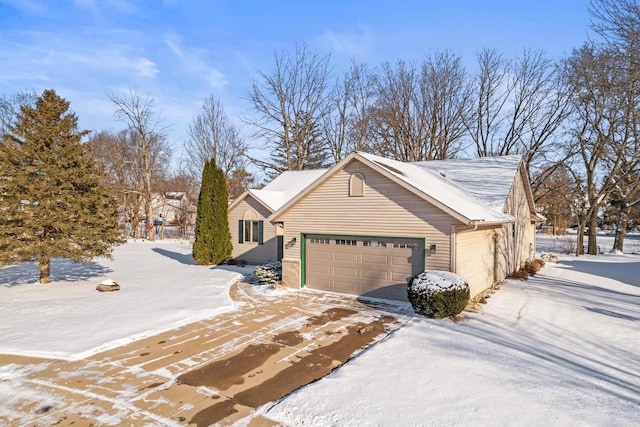 view of snowy exterior with a garage