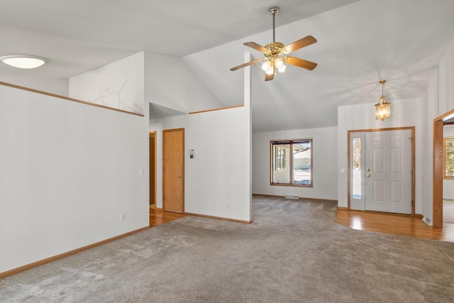 carpeted foyer featuring ceiling fan and high vaulted ceiling