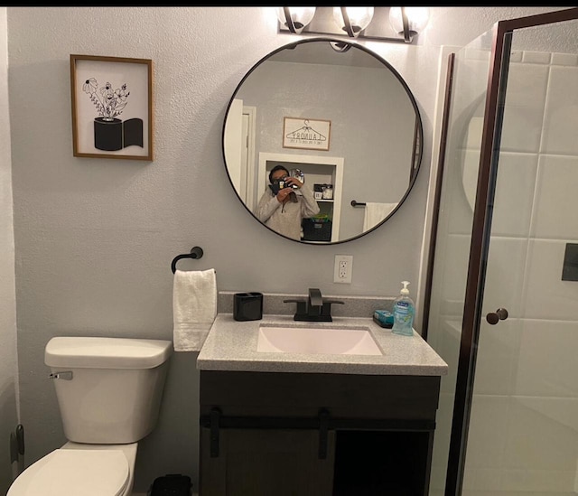 bathroom with vanity, a shower, and toilet