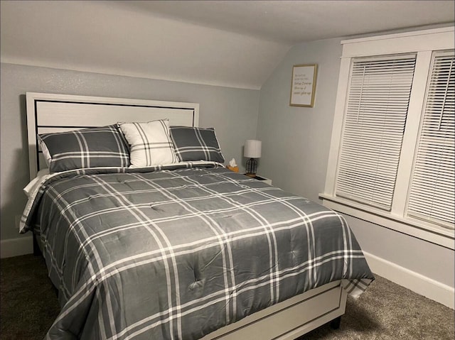 carpeted bedroom with lofted ceiling