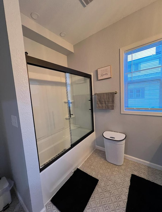 bathroom featuring bath / shower combo with glass door