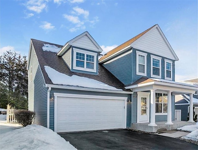 view of front of home featuring a porch, driveway, a shingled roof, and an attached garage