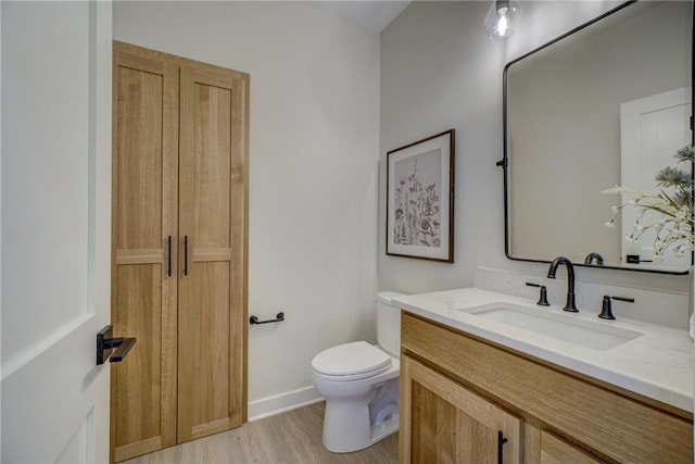 bathroom with vanity, wood-type flooring, and toilet