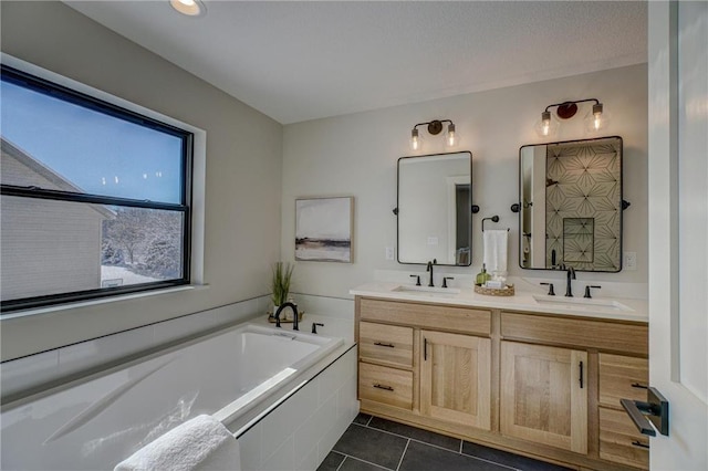 bathroom featuring a relaxing tiled tub, vanity, and tile patterned flooring