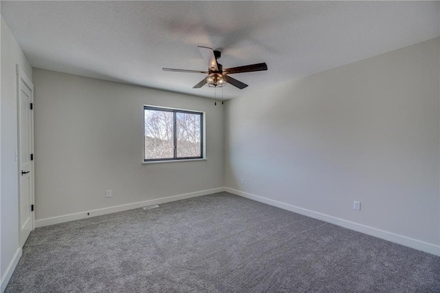 carpeted empty room with ceiling fan and a textured ceiling