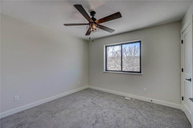 carpeted spare room featuring ceiling fan and a textured ceiling