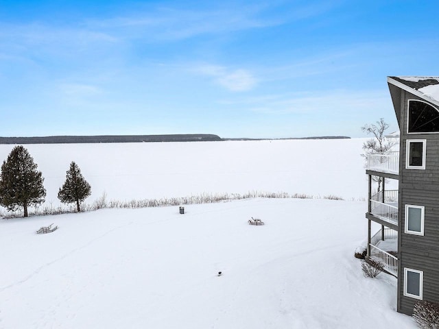 yard layered in snow featuring a balcony