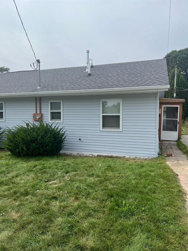 rear view of house featuring a lawn