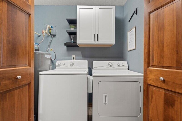 laundry room with cabinets, washing machine and dryer, and a textured ceiling