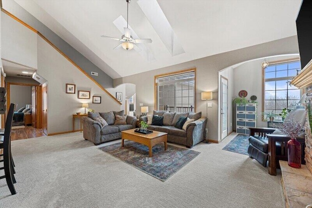 living room with ceiling fan, high vaulted ceiling, and light carpet