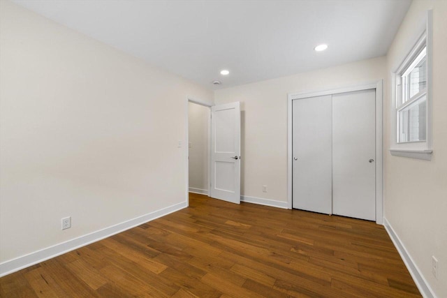 unfurnished bedroom featuring dark wood-type flooring and a closet