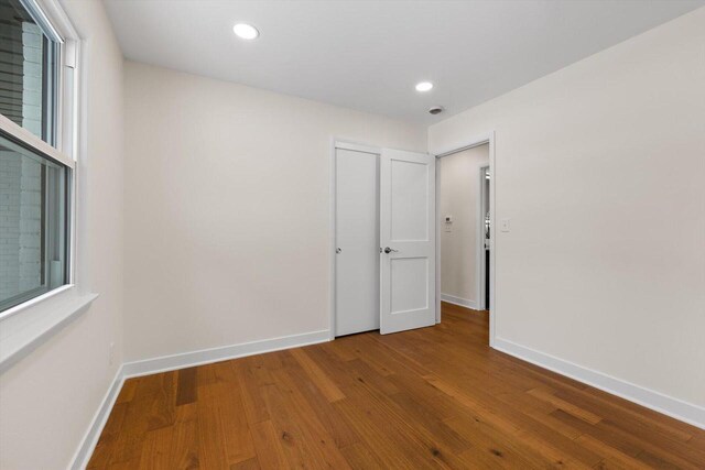 spare room featuring hardwood / wood-style flooring and plenty of natural light