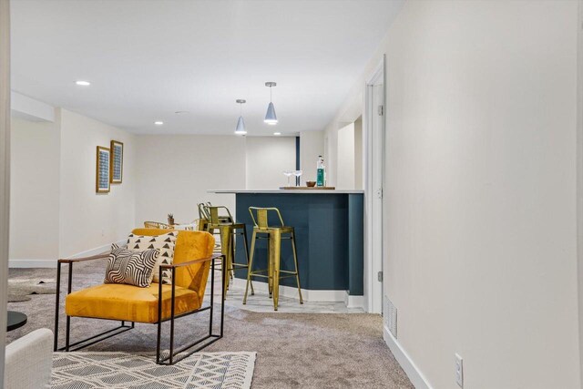living area featuring carpet floors and bar area